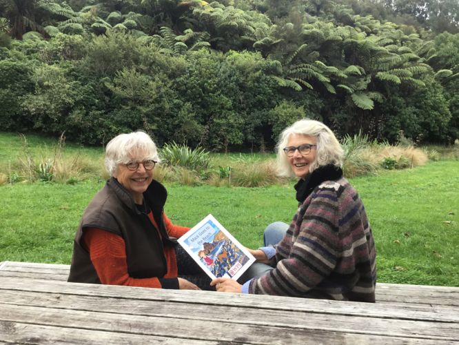 Trustee Heather Wallace shows Patron Dame Gaylene Preston 'Mack Goes to the Beach'. A wonderful children's story book showing how to take dogs to the beach and be wildlife friendly.